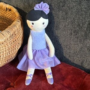 Ballerina doll wearing purple with dark colored hair and eyes